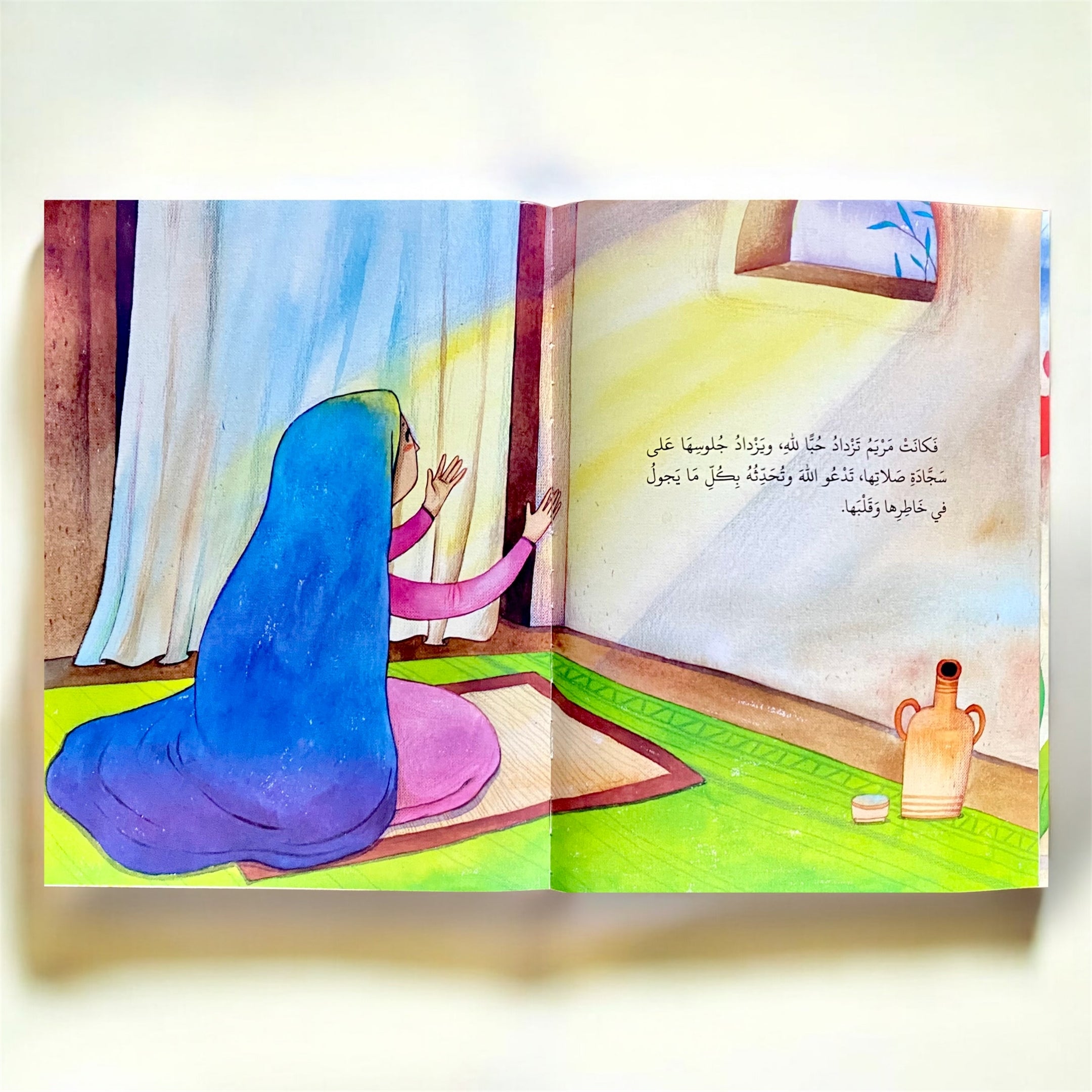 Illustration of a person in a blue hijab praying in front of a window.
