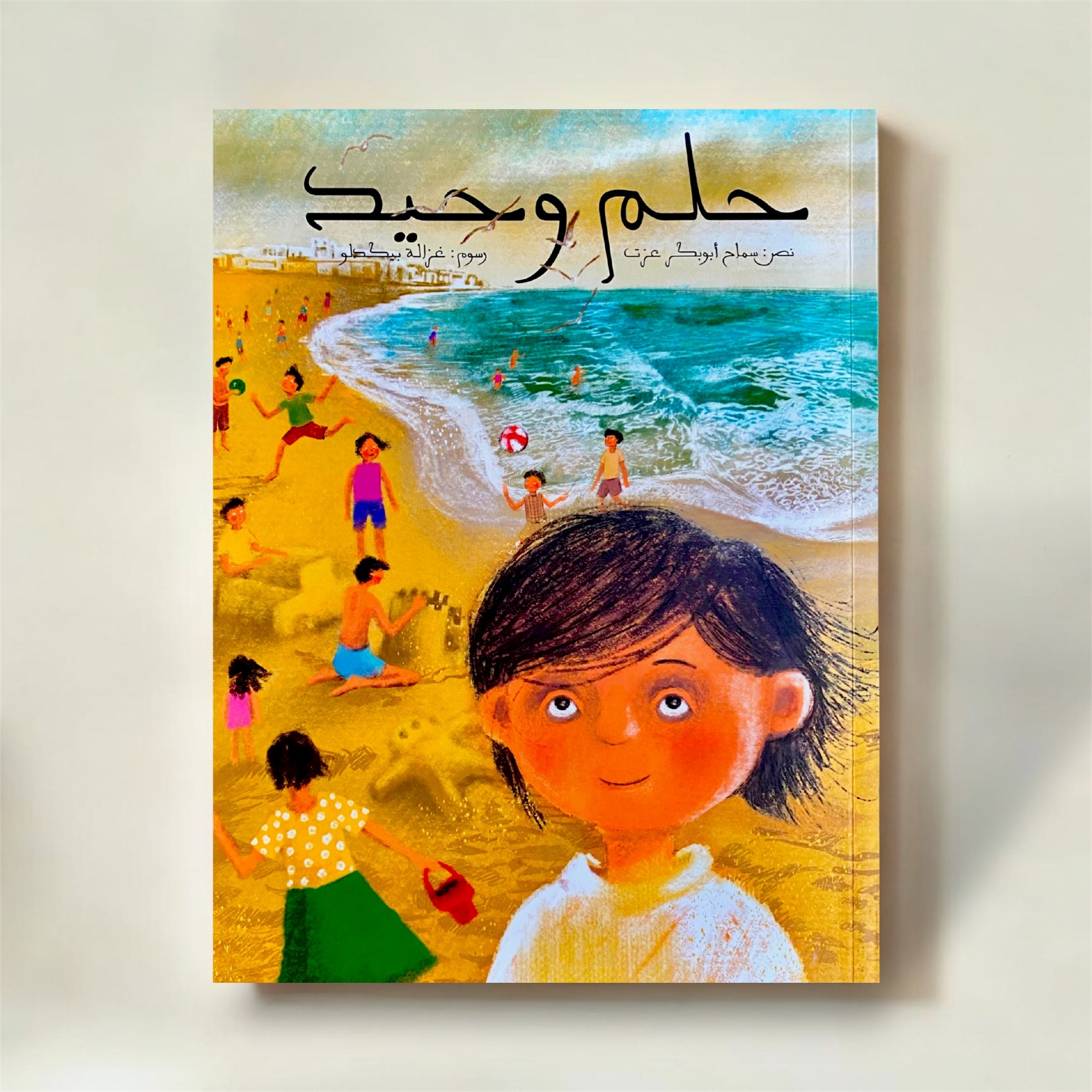 Book cover with a child on a beach and Arabic text