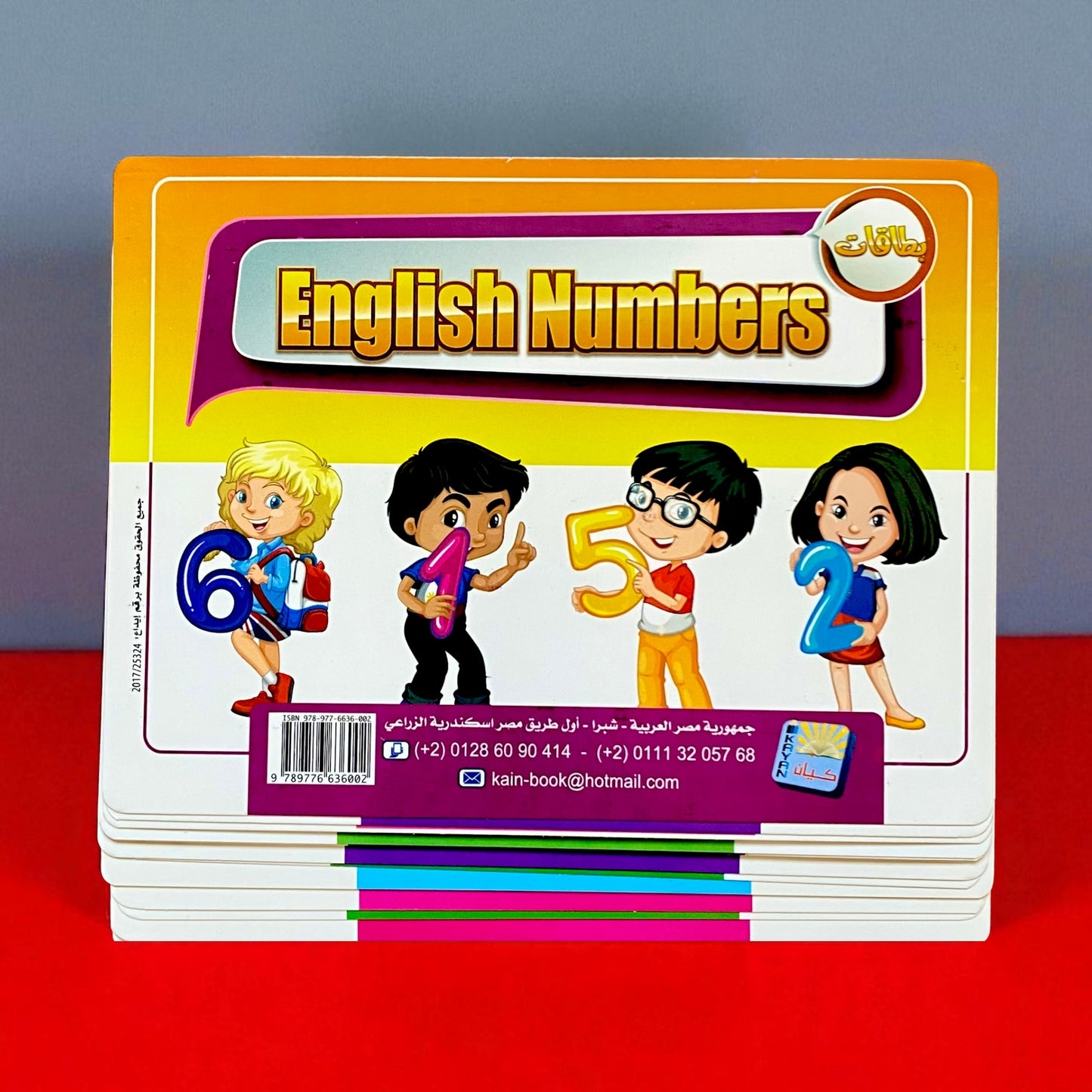 Children's book titled 'English Numbers' with cartoon characters on a red surface.